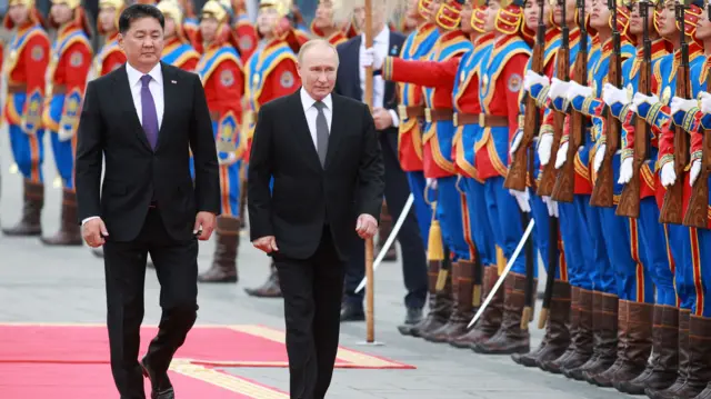 President Ukhnaagiin Khurelsukh and President Vladimir Putin review honour guards while walking down a red carpet