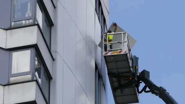 Workers remove external cladding from Braithwaite House, London July 2017