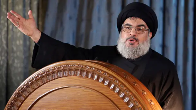 Hassan Nasrallah stands at a podium gesturing with his hand