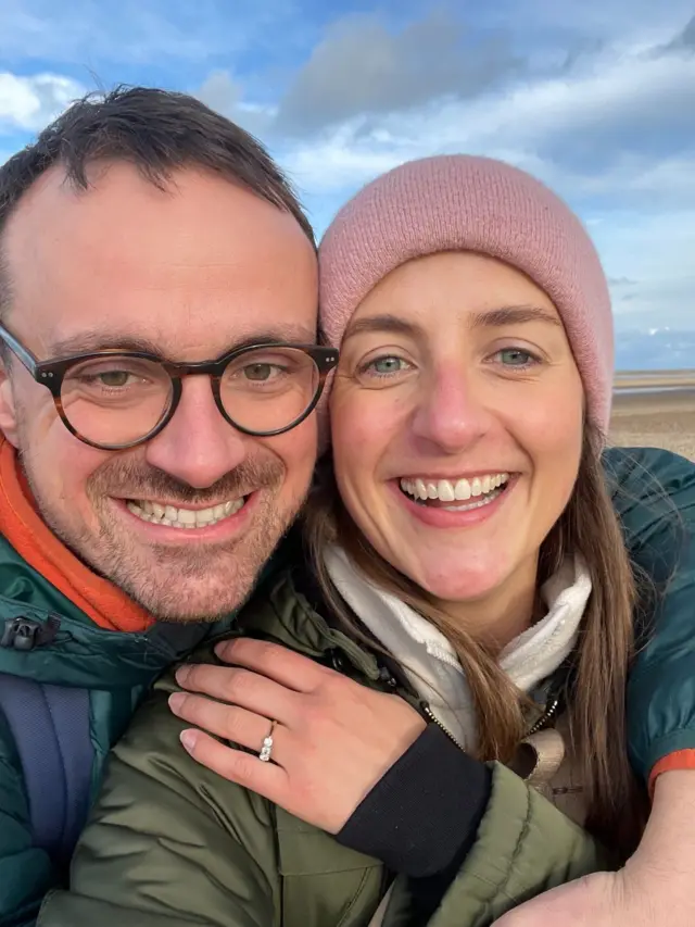 Georgina Russell and Oliver Jacques taking selfie on beach with engagement ring on show