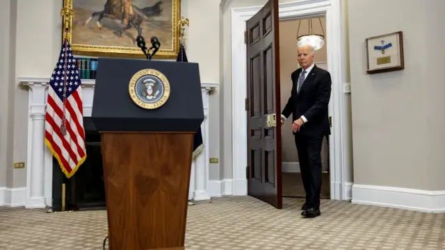 Biden turns to speak to reporters as he leaves a room of the White House