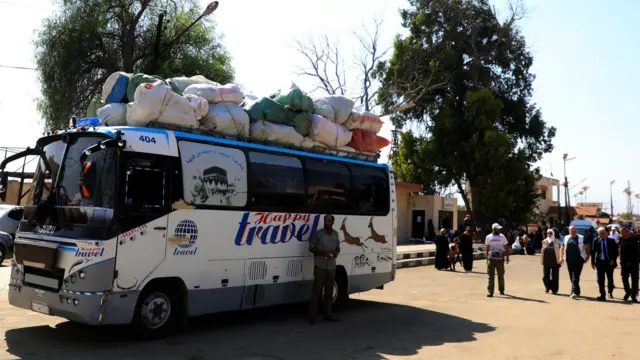 A bus with bags strapped to the top