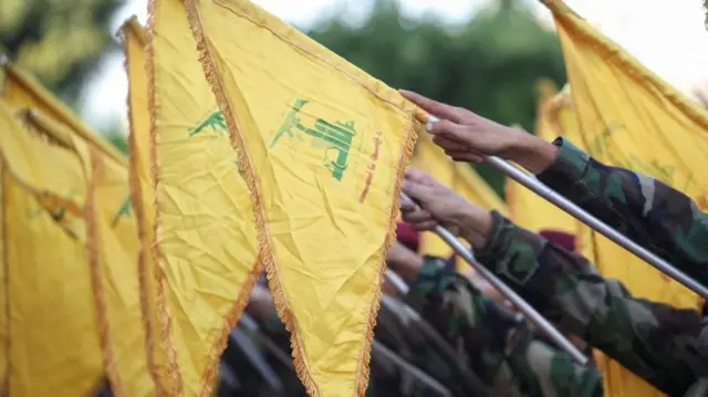 Hezbollah flags are held by its members at a funeral