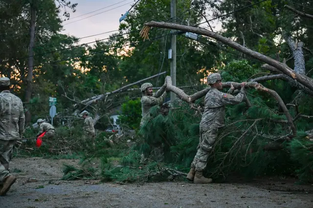 Troops cutting up a toppled tree