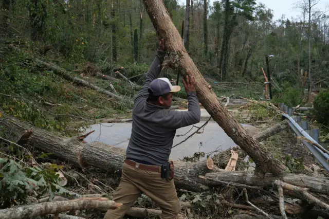 A man clears trees after the hurricane