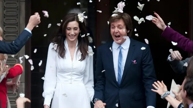 Paul McCartney and Nancy Shevell have confetti thrown over them as they leave the town hall