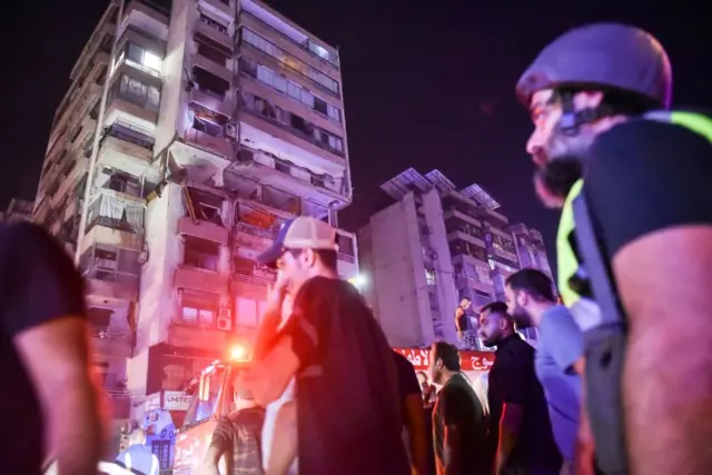 Apartment building shows damage with lights flashgin