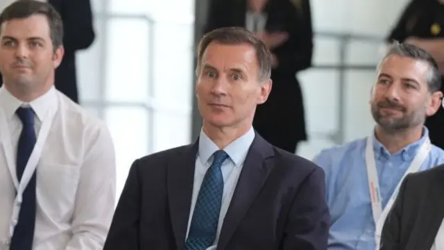 Jeremy Hunt sitting on chair listening to speech