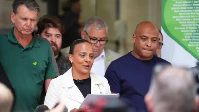 Natasha Elcock reading out a statement, other members of Grenfell united are standing behind her