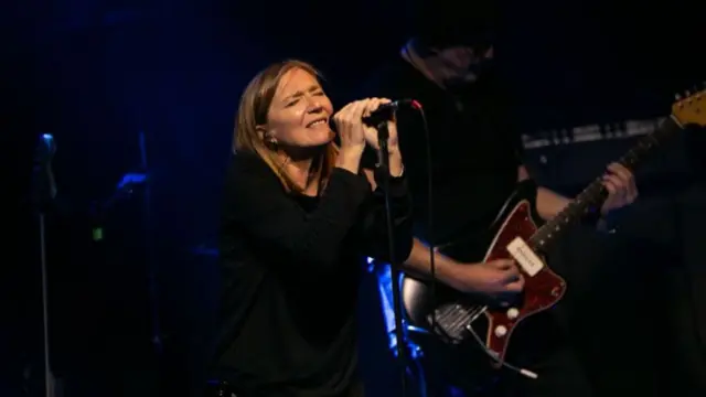 Beth Gibbons sings into a microphone while on stage.