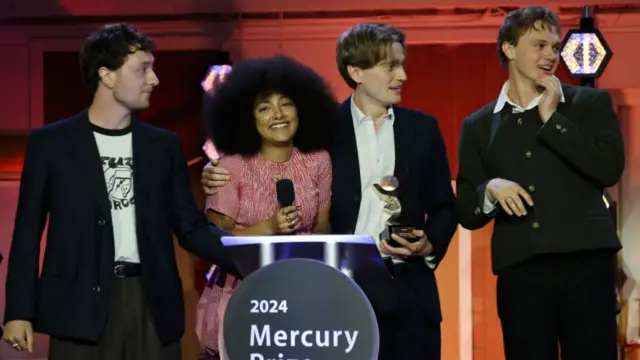 Lewis Whiting, Lily Fontaine, Nicholas Eden, and Douglas Frost of English Teacher onstage after winning the Mercury Music Prize