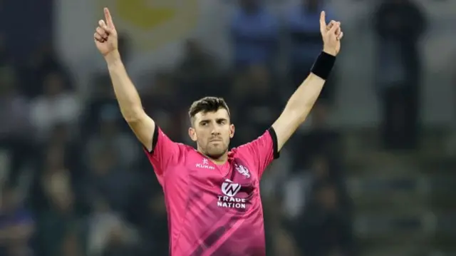 Craig Overton of Somerset celebrates after taking the wicket of George Bartlett