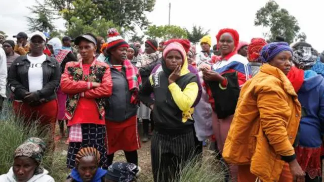 Lots of people standing in a crowd looking concerned