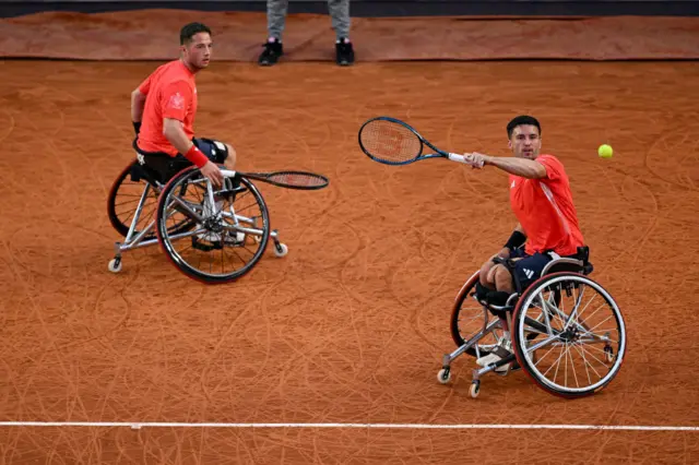 Gordon Reid hits a forehand during his Paralympic wheelchair tennis men's doubles semi-final, watched by partner Alfie Hewett