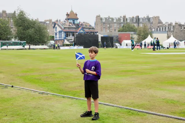 A young Scotland fan poses with a flag