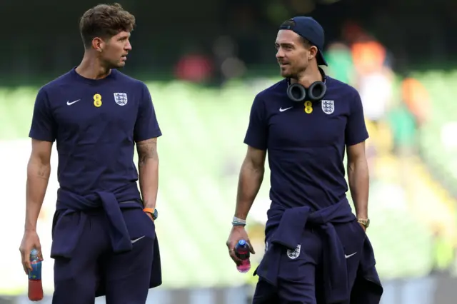 Stones and Grealish walk across the pitch