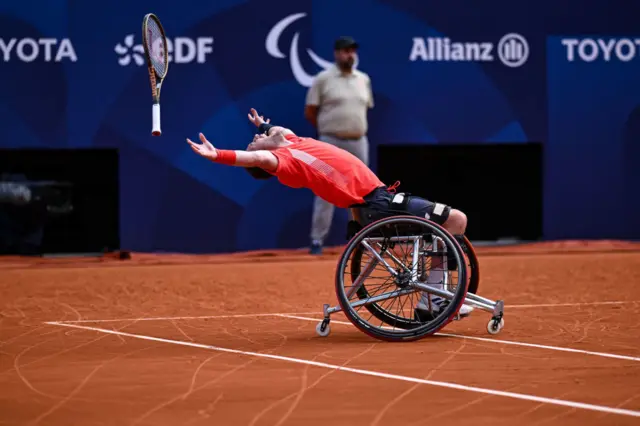 Alfie Hewett leans back in his wheelchair and throws his racquet into the air to celebrate Paralympics men's doubles gold