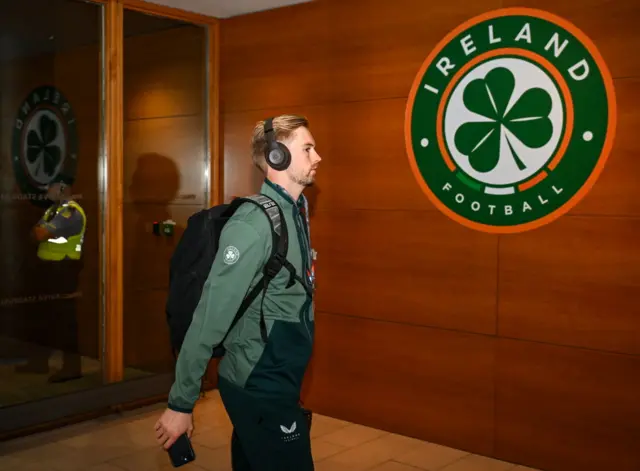 Kelleher arrives in the lobby of the stadium wearing headphones