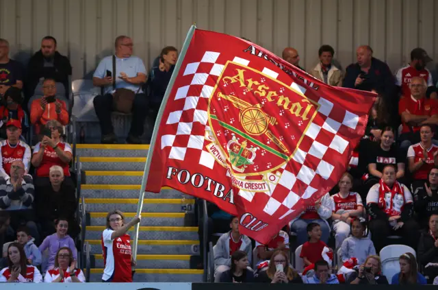 Arsenal fans fly a club crest flag in the stands