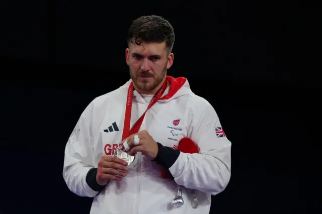 Daniel Powell clutches onto his silver medal on the podium