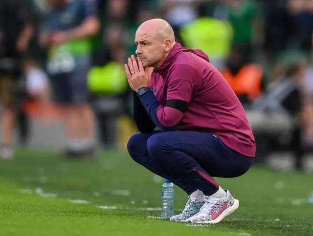 Lee Carsley looks deep in thought, crouching on the touchline, during England's win over the Republic of Ireland in Dublin on Saturday