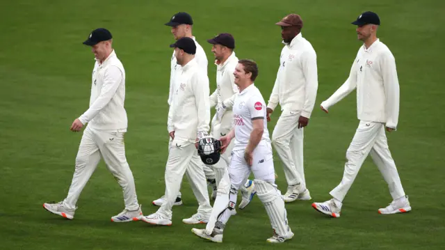 Hampshire batsman, Ben Brown walks off the pitch with the Kent players as bad light stops play and an early tea will be taken