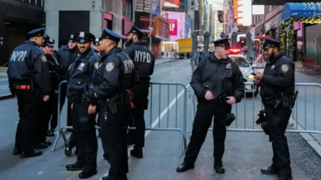 New York City Police Department (NYPD) officers stand watch in Times Square in New York City ahead of the New Year's Eve celebration on December 31