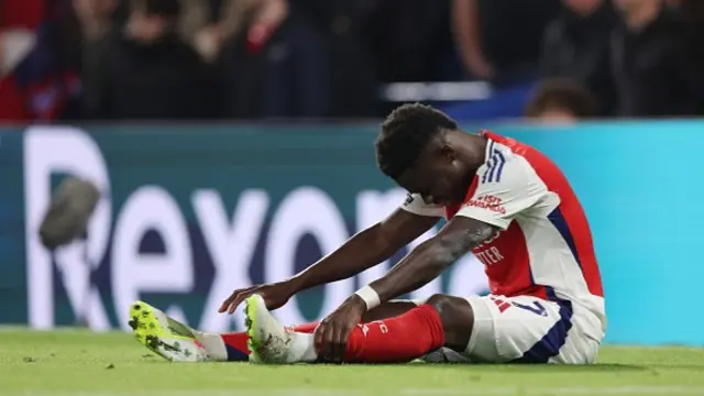 An injured Bukayo Saka of Arsenal sits on the pitch