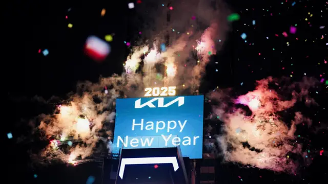 An electronic board displays "Happy New Year" as the fireworks go off after the ball drop at Times Square during New Year's celebrations in New York City