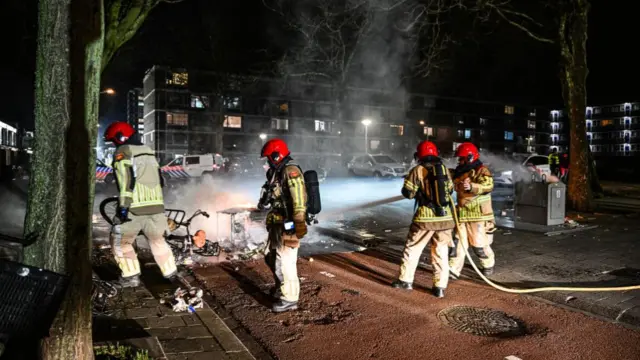 Members of the fire brigade put out a small fire caused by fireworks in Amsterdam