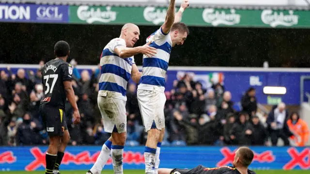 QPR goalscorer Jimmy Dunne raises both fists in the air as he celebrates over a Watford defender