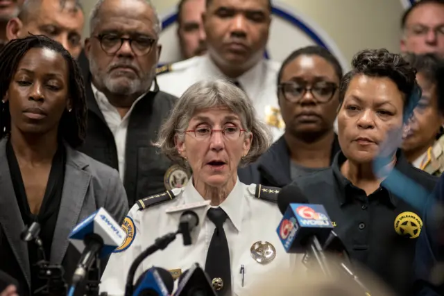 New Orleans Police Department Superintendent Anne Kirkpatrick, with a grey bob and pink rimmed glasses, speaking at a news conference
