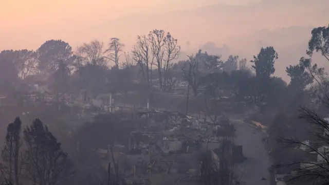 Burnt out houses along a road in daylight