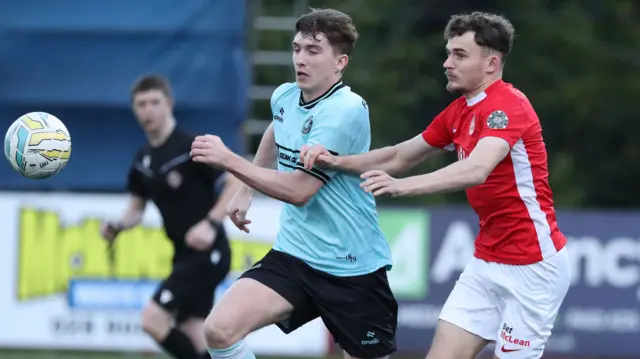 Cliftonville's Micheal Glynn and Benji Magee of Larne vie for possession