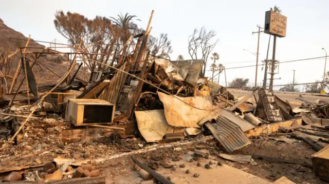 Pile of burnt debris where The Reel Inn used to stand with twisted metal sheets and rubble