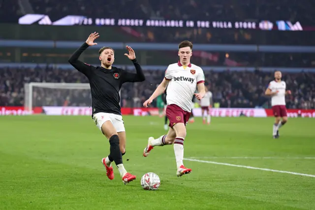 Matty Cash of Aston Villa and Ollie Scarles chases the ball down