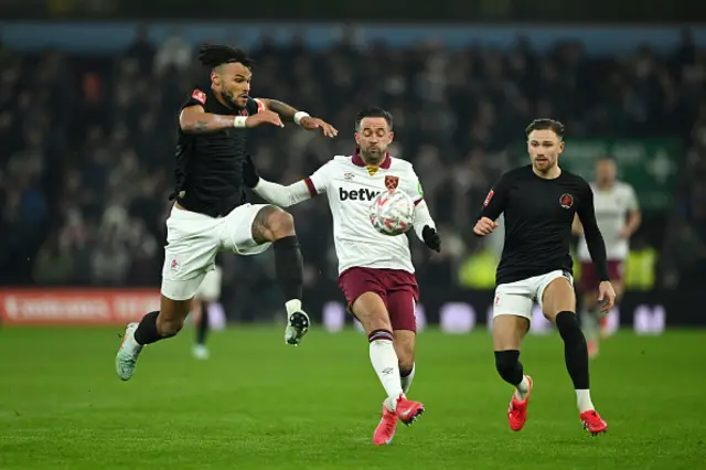 Tyrone Mings of Aston Villa looks to control the ball whilst under pressure from Danny Ing