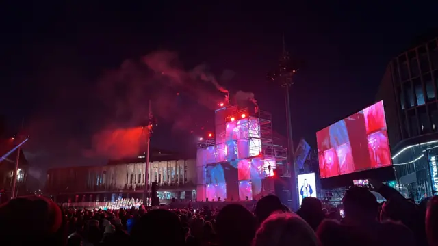 Stage with boxes lit up and performers in them