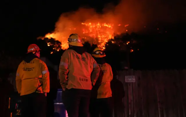 Firefighters from the Los Angeles County Fire Department stand vigilant as they battle wildfires in Los Angeles