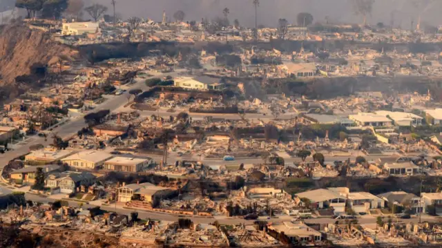 Aerial view of a residential district, with most houses burnt to the ground