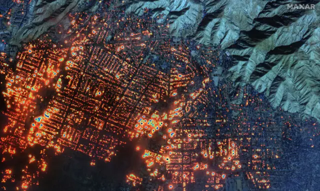 A satellite infrared image of burning buildings in Altadena. Thousands of properties are glowing red from the heat signature.