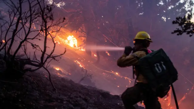 A firefighter battles wildfire in the Angeles National Forest