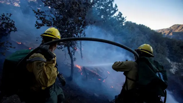 Firefighters battle the fire in the Angeles National Forest near Mt. Wilson