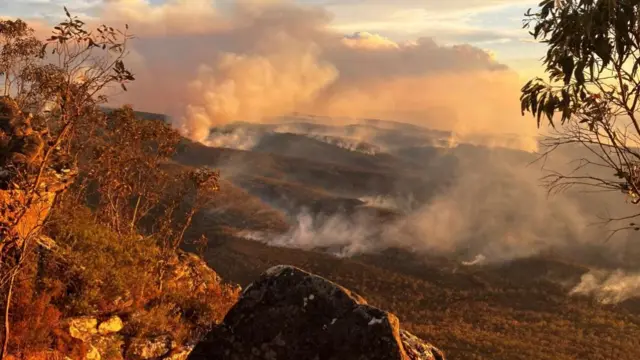 Wide show of Grampians National Park in Victoria with smoke billowing over the landscape