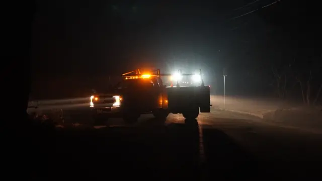 A pick-up truck with flashing lights in the darkness