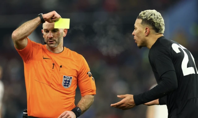 Aston Villa's Morgan Rogers is shown a yellow card by referee Tim Robinson