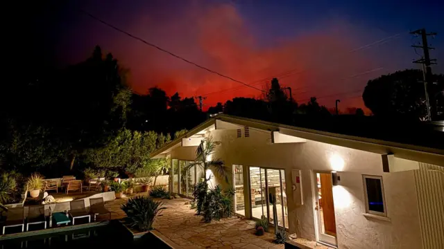 Bonnie and Jason's house, with the glow of the Eaton fire rising behind it in the night sky