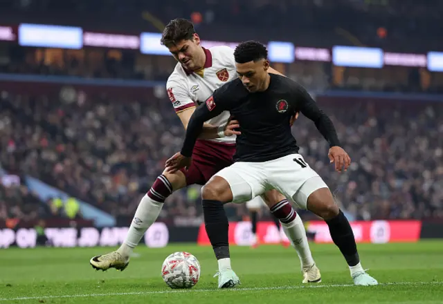 Ollie Watkins of Aston Villa is challenged by Konstantinos Mavropanos