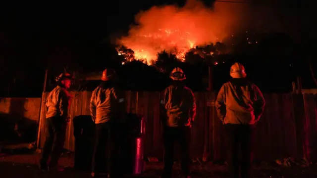 Firefighters from the Los Angeles County Fire Department stand vigilant as they battle wildfires in Los Angeles while several blazes continue to tear through the region