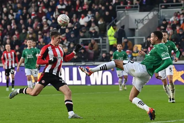 Brenan Galloway clears under pressure from Brentford's Yehor Yarmolyuk